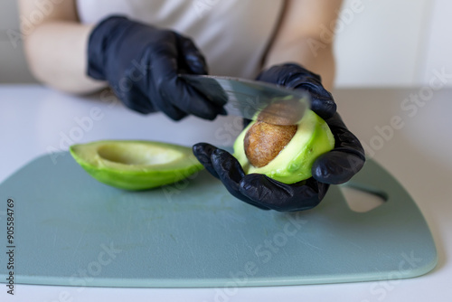 A girl holding an avocado in close-up. Avocado with a bone. Take out the avocado pips photo