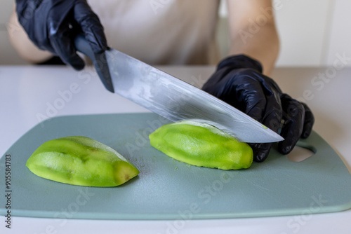 Girl slicing avocado in close-up. Cooking avocado photo