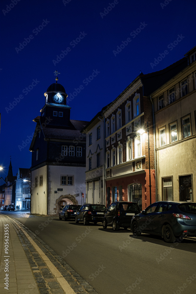 Street alley in the small town of Schwabisch Hall, with houses and buildings with typical German architecture and street lanterns, at night.