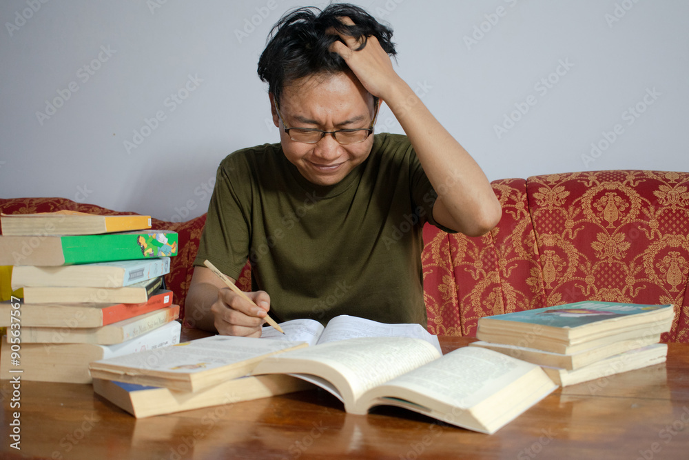 Asian young male reading book with frustrated gesture. Asian male with glasses confused face with Isolated white background Asian young male reading book with frustrated gesture. Asian male with glasses confused face with Isolated white background