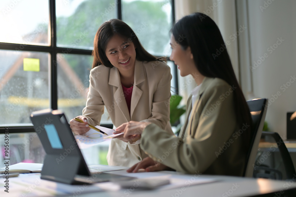 Two Professional Women Collaborating in a Modern Office Setting with Natural Light Two Professional Women Collaborating in a Modern Office Setting with Natural Light