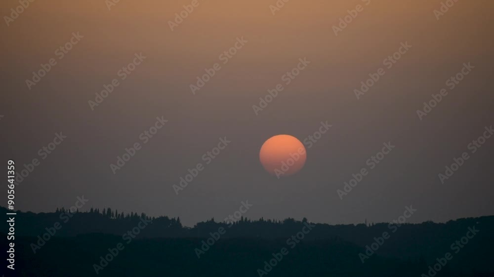 Epic sunset landscape sky with big bright sun going behind the mountains in Greece Epic sunset landscape sky with big bright sun going behind the mountains in Greece