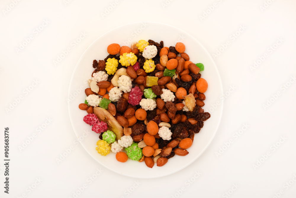 Sweet assorted nuts and dried fruits in a plate on a white background. Sweet assorted nuts and dried fruits in a plate on a white background.