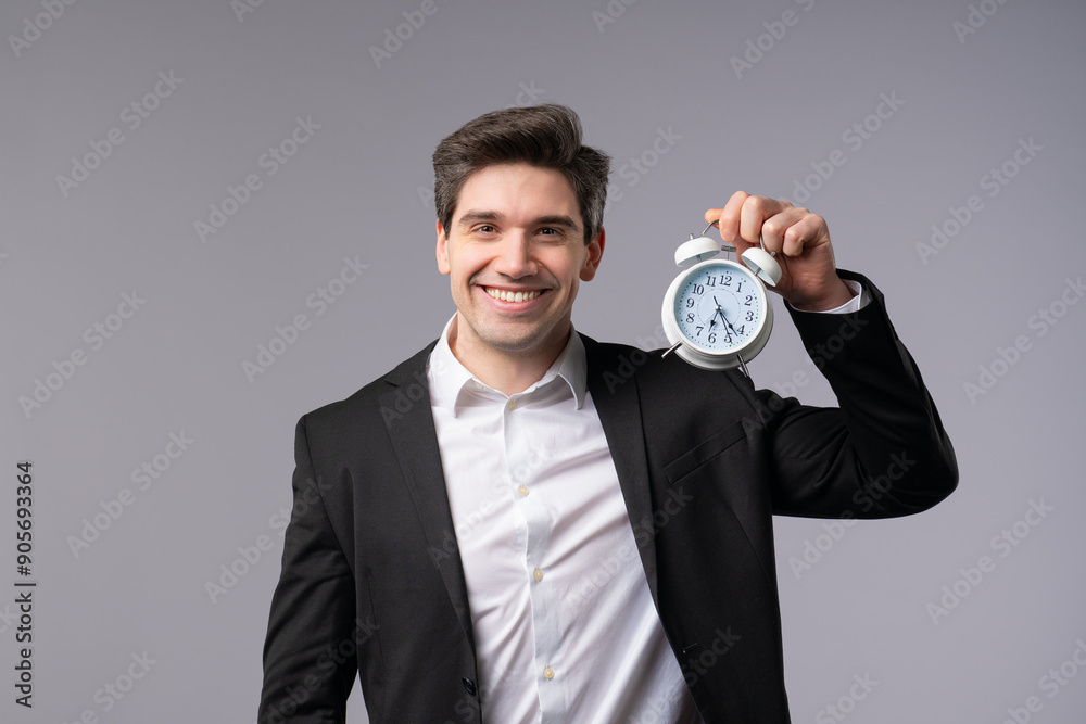 Happy businessman with clock on grey background. End of working day in office. Happy businessman with clock on grey background. End of working day in office.