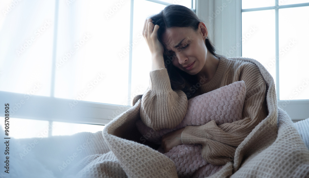 Sad, depressed, frustrated, angry, lonely, emotional young woman with severe stress and mental problem, disease, headache, illness, divorce, victim of violence. Female sitting on big window sill Sad, depressed, frustrated, angry, lonely, emotional young woman with severe stress and mental problem, disease, headache, illness, divorce, victim of violence. Female sitting on big window sill