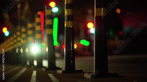 A city road with luminous barrier and blurred car moving along a fence in a night metropolis. The traffic in the night city. 4K