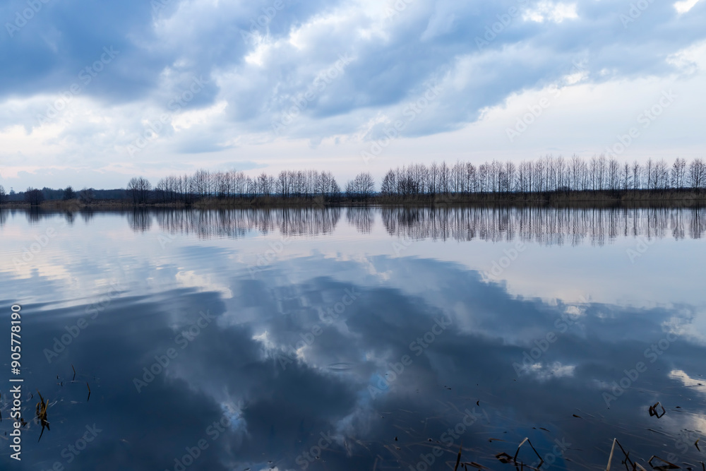 a beautiful reflection of the sky and clouds in the lake at sunset