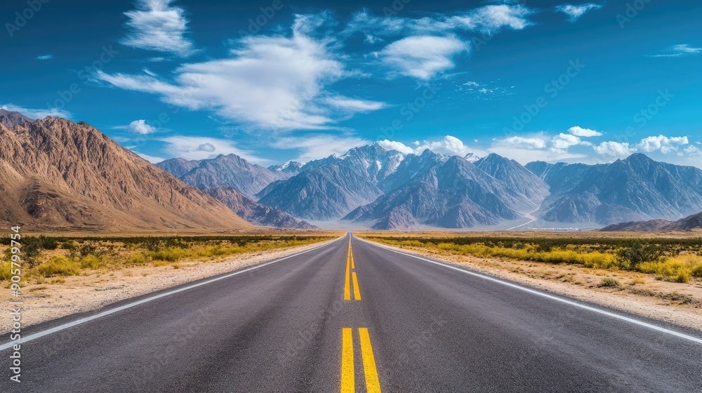 Naklejka premium Roadside scenery featuring a highway with tall mountains and a blue sky