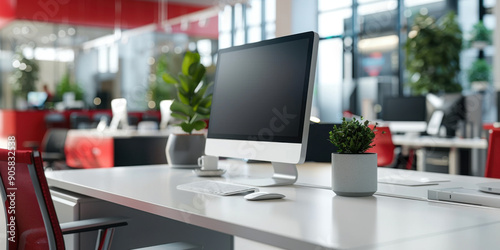 A clean and organized modern office workspace featuring a desktop computer, green plants, and a bright, open environment.