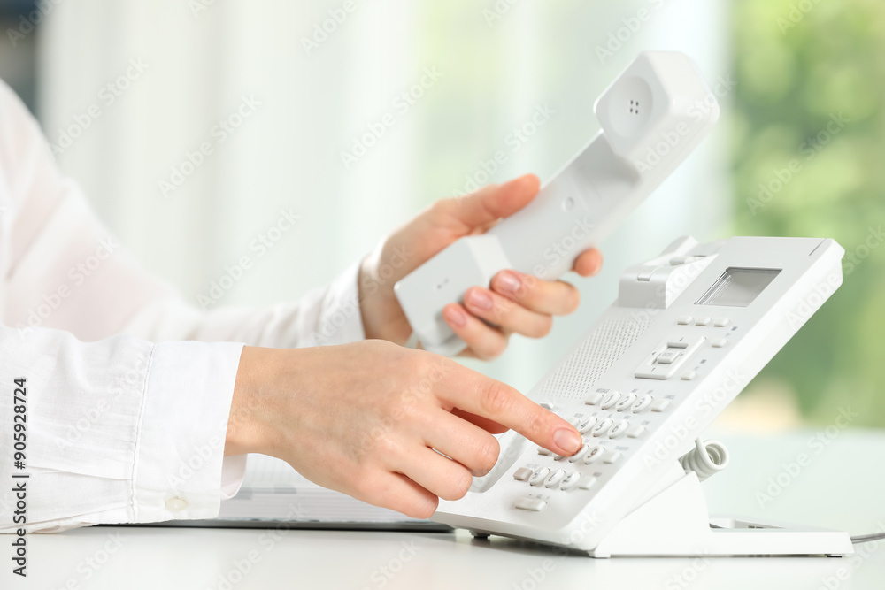 Assistant dialing number on telephone against blurred background, closeup Assistant dialing number on telephone against blurred background, closeup