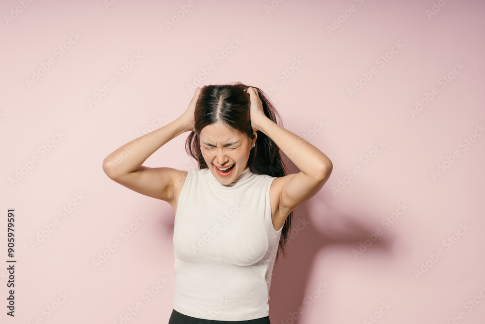 Frustrated Young Woman Expressing Stress and Anxiety Against a Pink Background Frustrated Young Woman Expressing Stress and Anxiety Against a Pink Background