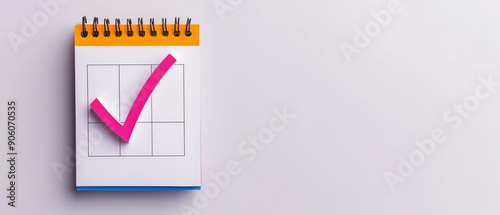 Close-up of a calendar with a pink checkmark, symbolizing completed task or goal. Minimalist design with ample white space for text. photo