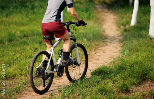 Woman biker mountain biking on mountain forest trail