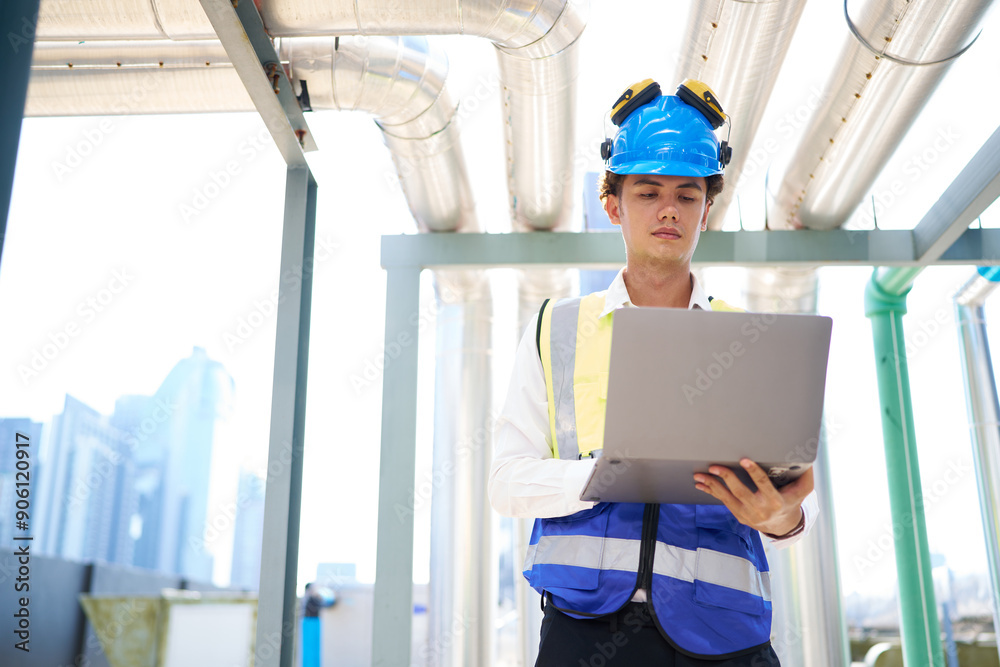 Engineer or technician working on laptop computer and checking air conditioner control valve at plumbing systems Engineer or technician working on laptop computer and checking air conditioner control valve at plumbing systems