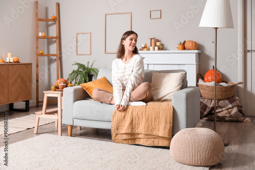 Young woman sitting on sofa...