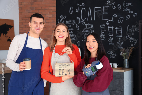 Young baristas with OPEN si...