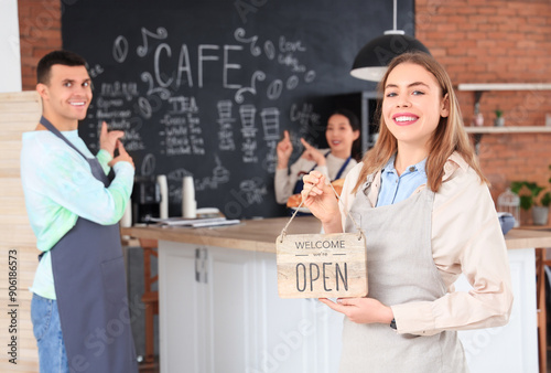 Female barista with OPEN sign in coffee shop