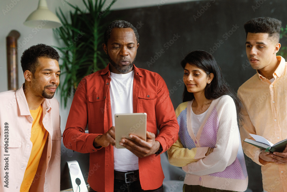 © Oleksii Syrotkin/Stocksy - Creative group running business. Looking at tablet in office © Oleksii Syrotkin/Stocksy - Creative group running business. Looking at tablet in office