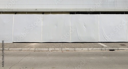 Ground floor of a building protected by tarpaulins for privacy. Concrete sidewalk and street in front. Background for copy space. photo