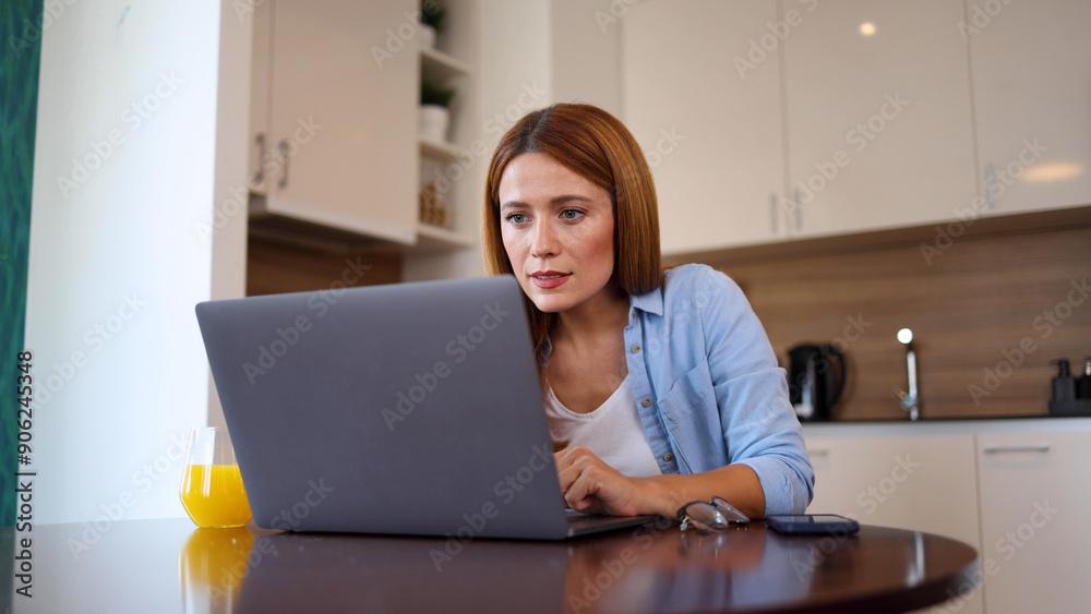 Woman browsing the internet on her laptop at home Woman browsing the internet on her laptop at home