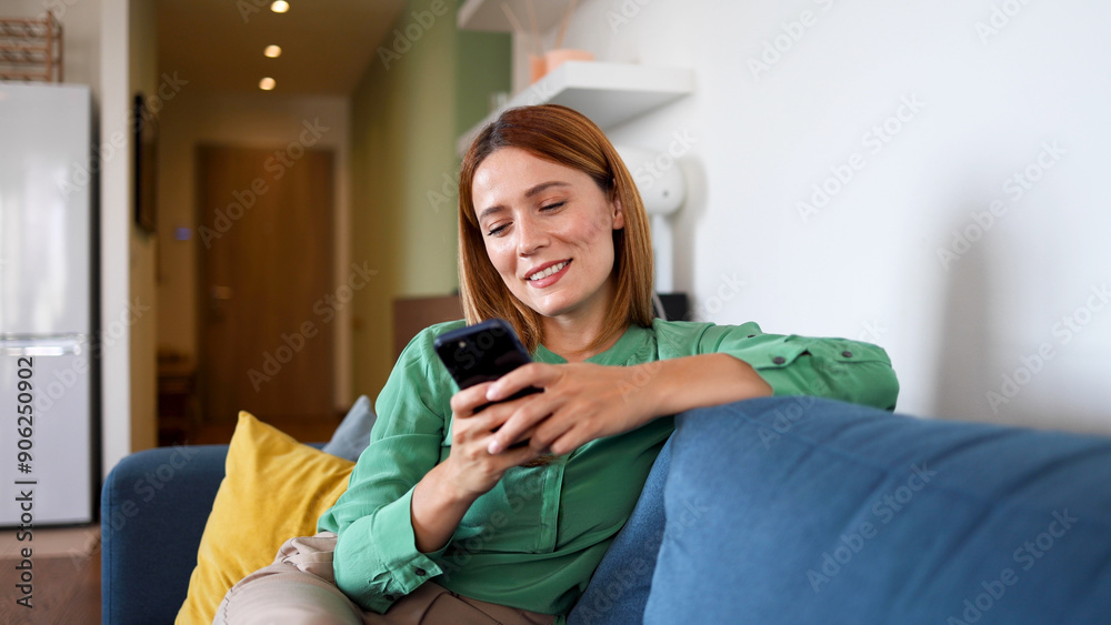 Obraz premium Woman relaxing on the couch and using smartphone