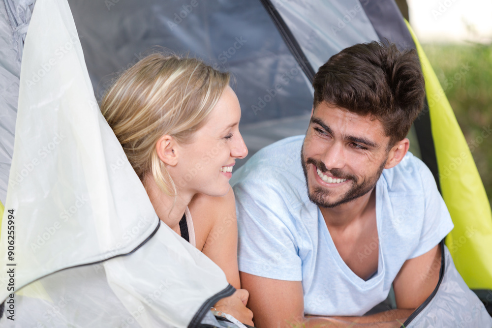 Obraz premium young couple lying at the entrance to their tent