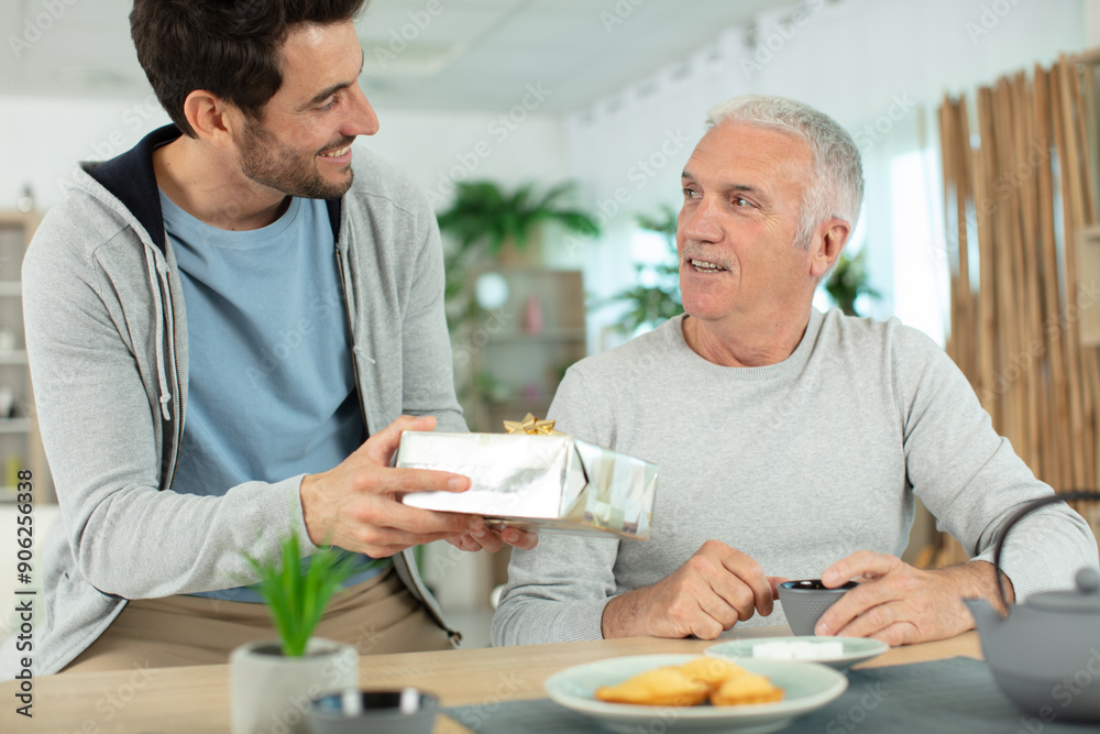 one man giving a present to another man one man giving a present to another man