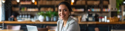 Businesswoman having a successful entrepreneurship career Happy woman working at a table with a laptop analyzing a document in a cafe or a cozy office setting Contemporary business practice