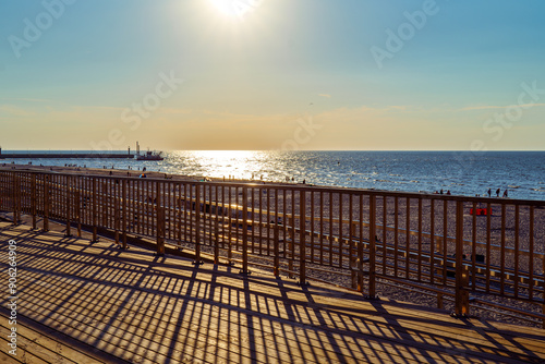 Obraz na płótnie View from the wooden observation deck towards the sea. Sunset. Shadows of steel balustrades. Leba, Baltic sea, Poland w salonie