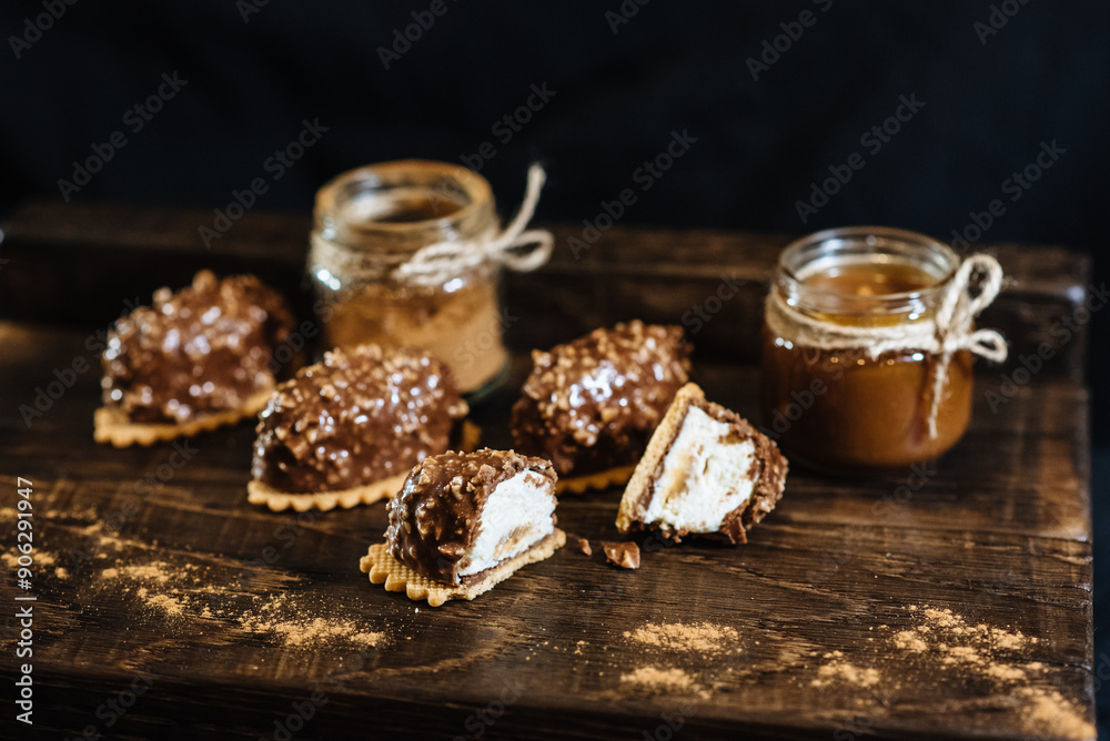 Fototapeta premium Mini dessert in a modern version. Portion cheesecake covered with chocolate and nuts. Fashionable French chocolate cake.