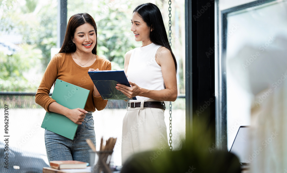 Smart casual Business women standing next to a window and discussing their ideas.