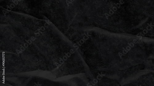 Crumpled black paper stop motion, paper texture background. 4K resolution, seamless looping