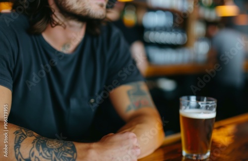 Close-Up of a Tattooed Man Enjoying Beer in a Cozy Bar Setting