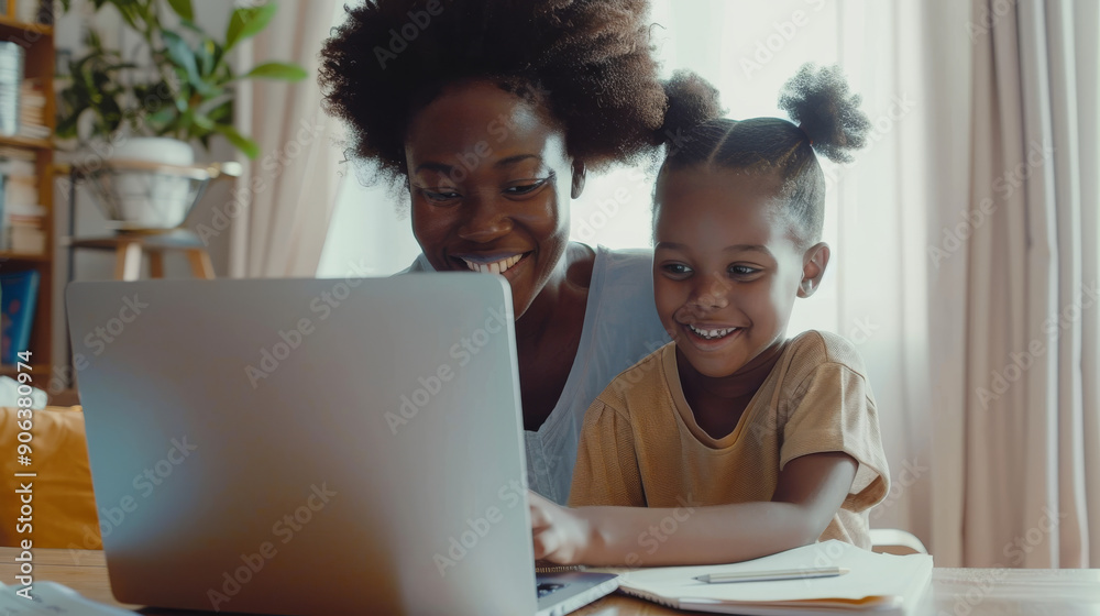 A joyful mother and child share a moment at the laptop, both smiling as they engage in an educational activity together. A joyful mother and child share a moment at the laptop, both smiling as they engage in an educational activity together.