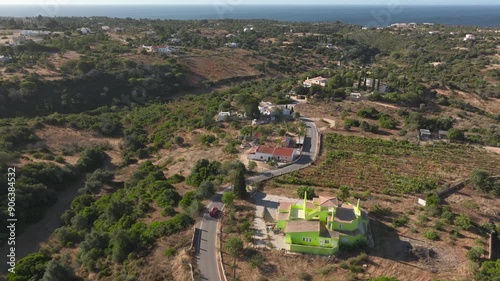 Cinematic aerial view of Benagil Caves and Beach at Algarve - Portugal. Surfer Car driving to beach long drone follow shot. 
