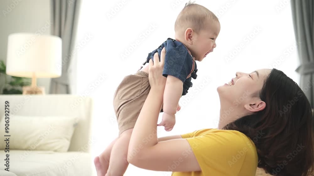 A tiny child smiling happily on the couch in the living room with mom A tiny child smiling happily on the couch in the living room with mom