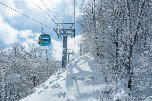 Pyeongchang-gun, Gangwon-do, South Korea - February 27, 2020: Winter view of gondolas driving on the cable against pillars and snow coverd Balwangsan Mountain 