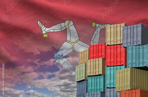 Isle of Man flag and big stack of shipping cargo containers in docks with sky background close up photo