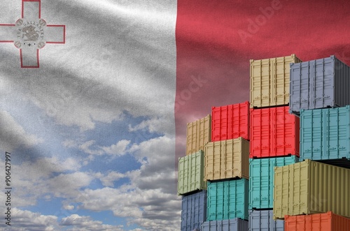 Malta flag and big stack of shipping cargo containers in docks with sky background close up photo