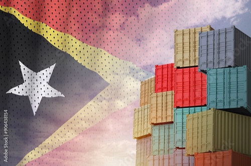 Timor Leste flag and big stack of shipping cargo containers in docks with sky background close up photo