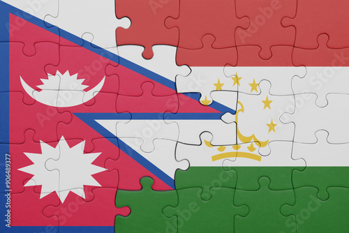 puzzle with the colourful national flag of nepal and flag of tajikistan . photo