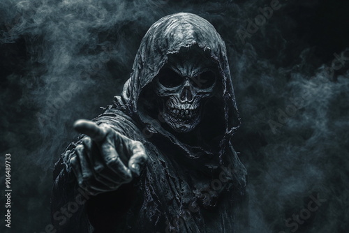 hooded figure with a skeleton face pointing frontally with the finger in a misty spooky atmosphere photo