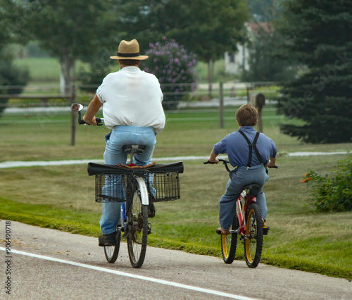 View of an Amish father and son on bicycles