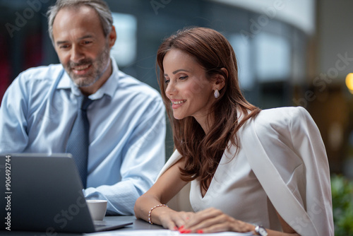 Two business people working outdoor with laptop, stock photo