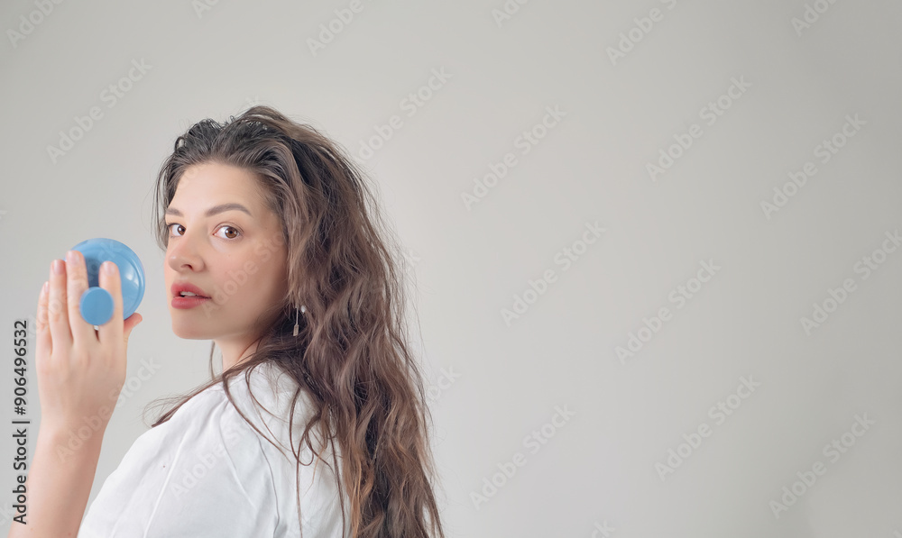 Profile portrait of a smiling girl holding a head massager, promoting relaxation of head and neck muscles through regular massage. Profile portrait of a smiling girl holding a head massager, promoting relaxation of head and neck muscles through regular massage.
