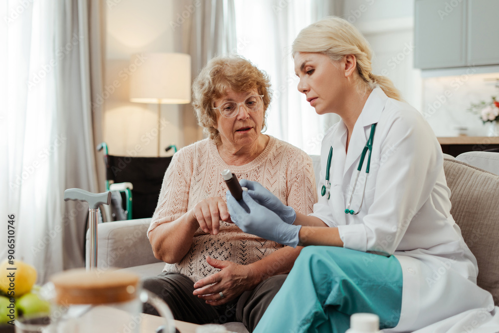Obraz premium Doctor explaining medication to elderly woman at home