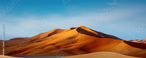 Vast desert landscape featuring stunning orange dunes under a clear blue sky, showcasing the beauty of nature's formations.