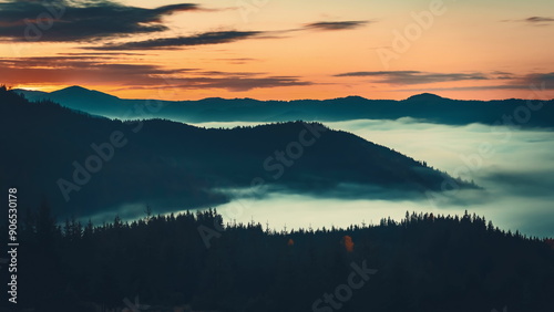 The sun's first rays light up carpathian peaks, casting shadows on slopes with fog adding mystery and serenity