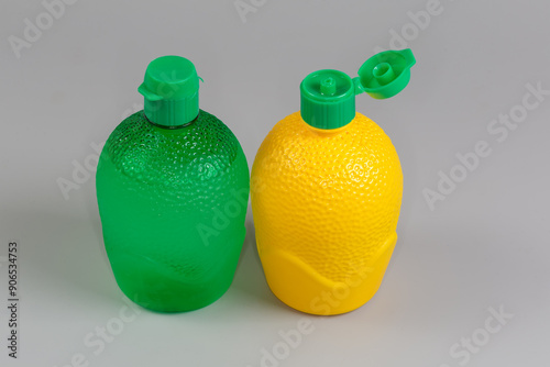 Lime and lemon juice concentrate in containers on gray background