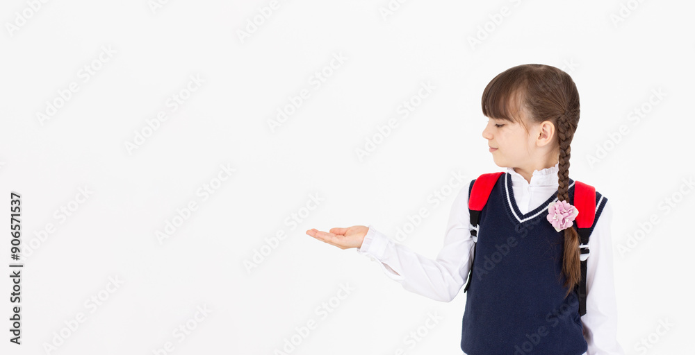 Image of european primary school student on white background pointing and looking left Image of european primary school student on white background pointing and looking left